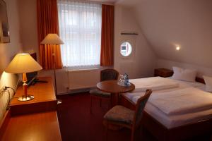 グライフスヴァルトにあるHotel Am Domのベッドとテーブルが備わるホテルルームです。