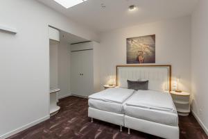 ein Schlafzimmer mit einem großen weißen Bett und zwei Tischen in der Unterkunft Hotel MOA Berlin in Berlin + 55 Fotos