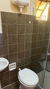 a bathroom with a toilet and a sink at Suites Casa Amarela in Cabo Frio