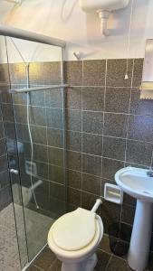 a bathroom with a toilet and a sink at Suites Casa Amarela in Cabo Frio
