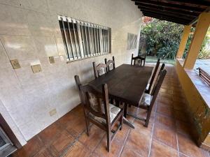 a dining room with a wooden table and chairs at Suites Casa Amarela in Cabo Frio