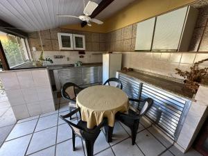 a kitchen with a table and chairs in a kitchen at Suites Casa Amarela in Cabo Frio