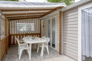 taras z białym stołem i krzesłami w obiekcie Mobil-home 2 chambres - B w mieście Saint-Jean-de-Monts +12 zdjęć