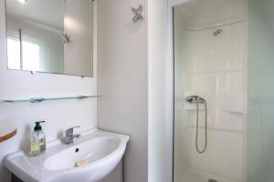 biała łazienka z umywalką i prysznicem w obiekcie Mobil-home 2 chambres - B w mieście Saint-Jean-de-Monts