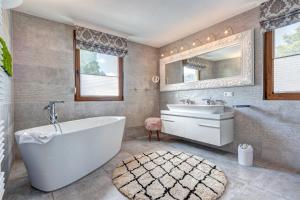 a bathroom with a tub and a sink and a mirror at Haus Kieferngrund in Ahlbeck +38 photos