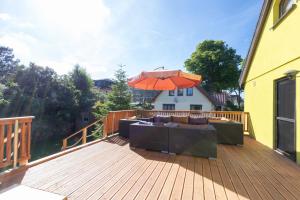 a deck with a couch and an umbrella at Haus Kieferngrund in Ahlbeck
