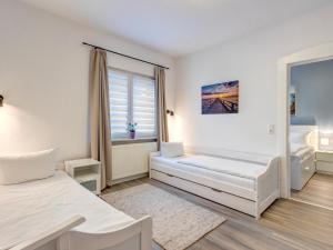 a white room with two beds and a window at Haus Barnheide - Wohnung Sandburg in Bansin +12 photos