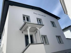 a white building with a sign on the side of it at Haus Barnheide - Wohnung Sandburg in Bansin