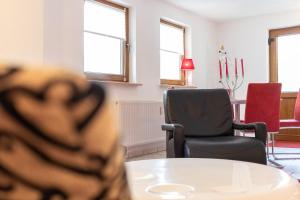 ein Raum mit Tisch und Stühlen und Fenstern in der Unterkunft Ferienwohnung Kieferngrund in Ahlbeck