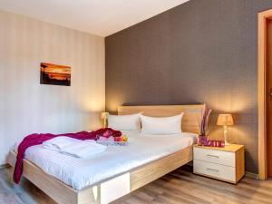 a bedroom with a bed with white sheets and a table at Gartenoase Ahlbeck -01 in Ahlbeck +4 photos