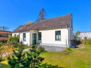 a white house with a green door in a yard at Gartenoase Ahlbeck -01 in Ahlbeck