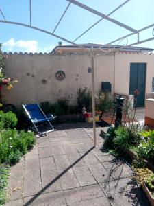 un patio con una sombrilla en un jardín en Il Coccio, en Nuoro