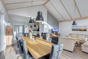 a dining room and living room with a wooden table and chairs at Haus Henny mit Sauna in Heringsdorf