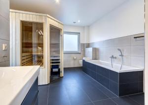 a bathroom with a tub and a sink at Haus Henny mit Sauna in Heringsdorf