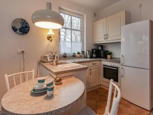 a kitchen with a table and a white refrigerator at Villa Christiane Wohnung 8 in Heringsdorf +1 photo