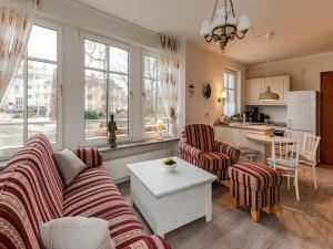 a living room with two couches and a kitchen at Villa Christiane Wohnung 8 in Heringsdorf