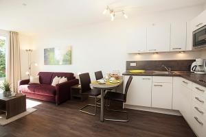 a kitchen and living room with a table and a couch at Residenz am Balmer See - BS 03 mit Wellnessbereich in Balm