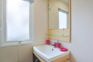 a bathroom with a sink and a mirror at Mobilhome tout équipé bois masson in Saint-Jean-de-Monts +13 photos