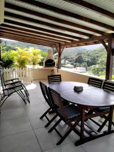 a dining room with a wooden table and chairs at Grand T2 avec piscine privative in Les Trois-Îlets