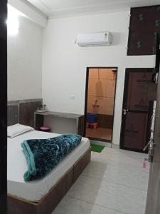 a bedroom with a bed and a bathroom with a mirror at Hotel Raj krishnam khatushyamji in Khātu