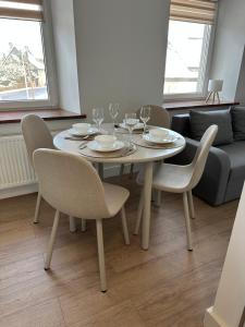 a dining room table with chairs and wine glasses at Apartament Kryształ 2 in Piechowice