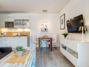 eine Küche und ein Esszimmer mit einem Tisch in einem Zimmer in der Unterkunft Residenz am Balmer See - BS 22 mit Wellnessbereich in Balm