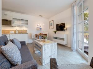 ein Wohnzimmer mit Sofa und Tisch in der Unterkunft Residenz am Balmer See - BS 22 mit Wellnessbereich in Balm