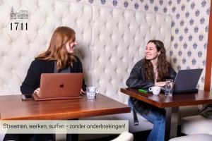 Zwei Frauen sitzen mit ihren Laptops an einem Tisch. in der Unterkunft Hotel 1711 in Valkenburg + 48 Fotos