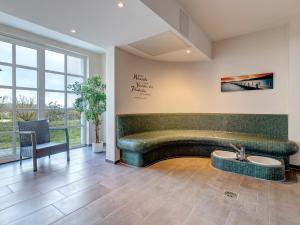 a lobby with a green couch and a table at Residenz am Balmer See - BS 11 mit Wellnessbereich in Balm