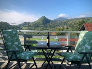 una mesa con una botella de vino y dos sillas en Eros & Aphrodite, en Samobor