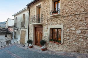 a stone building with two balconies and a wooden door at Casa Adela - Luxury Rural Accommodation in Castellonet