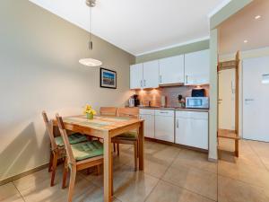 a kitchen and dining room with a wooden table and chairs at Residenz am Balmer See - BS 36 mit Wellnessbereich in Balm