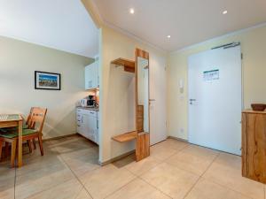 a kitchen and dining room with a table and a door at Residenz am Balmer See - BS 36 mit Wellnessbereich in Balm +15 photos