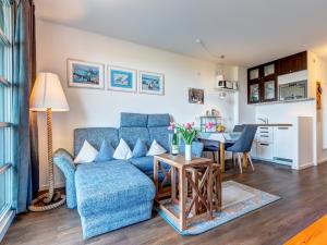 ein Wohnzimmer mit einem blauen Sofa und einem Tisch in der Unterkunft Residenz am Balmer See - BS 38 mit Wellnessbereich in Balm + 13 Fotos