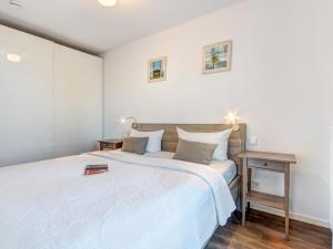 ein Schlafzimmer mit einem großen weißen Bett und einem Tisch in der Unterkunft Residenz am Balmer See - BS 38 mit Wellnessbereich in Balm