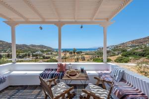a patio with chairs and a table with a view at Mylopota apartment IV in Ios Chora