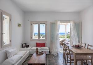a living room with a white couch and a table at Mylopota apartment IV in Ios Chora