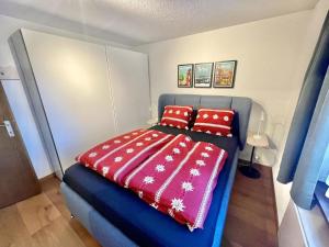una camera con letto blu e cuscini rossi di Apartment Linder by Interhome a Blankenburg Altre 3 foto