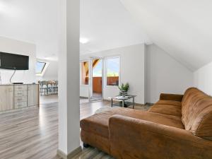 a living room with a brown couch and a tv at Apartment Beate by Interhome in Badacsonytomaj