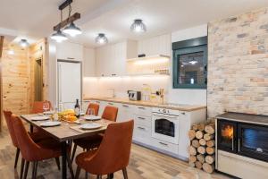 a kitchen with a table and chairs and a fireplace at Villa Vucje near Kolasin in Kolašin