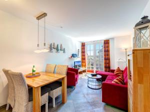 a living room with a table and a red couch at Residenz am Balmer See - BS 48 mit Wellnessbereich in Balm