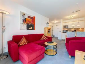 a living room with a red couch and a table at Residenz am Balmer See - BS 48 mit Wellnessbereich in Balm