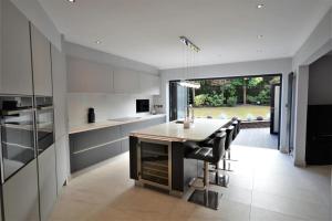 a kitchen with a table and some black chairs at Lavish4Bed Mansion in Warrington in Warrington