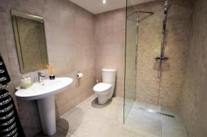 a bathroom with a toilet and a sink and a shower at Lavish4Bed Mansion in Warrington in Warrington +6 photos