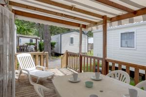 a patio with a table and chairs on a deck at Mobil-home 3 chambres - A1 in Saint-Jean-de-Monts