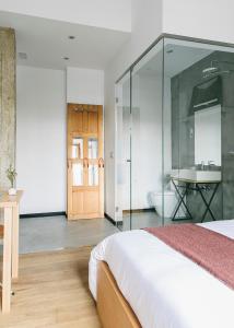 a bedroom with a bed and a bathroom with a sink at Guest House Ibaia Et Arramak in San Sebastián