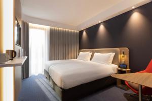 a hotel room with a white bed and a desk at Holiday Inn Express & Suites - Deventer by IHG in Deventer