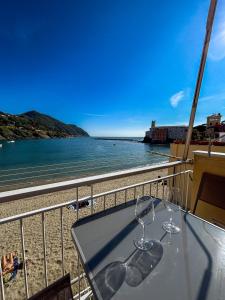 a table with wine glasses on a balcony overlooking the beach at La Terrazza Sulla Baia The Balcony By The Bay in Sestri Levante +13 photos