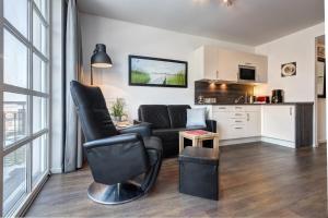 a living room with a couch and a kitchen at Residenz am Balmer See - BS 56 mit Wellnessbereich in Balm