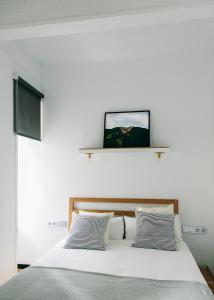 a bedroom with a white bed with two pillows at Guest House Ibaia Et Arramak in San Sebastián